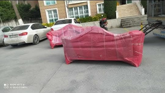 Sokakta koruyucu örtü ve streç filmle paketlenmiş kırmızı koltuklar